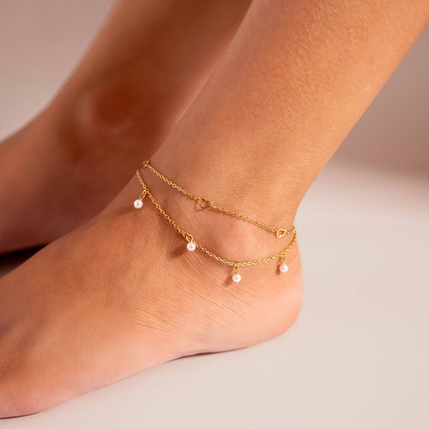 Gold anklet with dainty pearl charms styled on ankle – layered, waterproof beach jewelry by Lauren Riley Jewelry