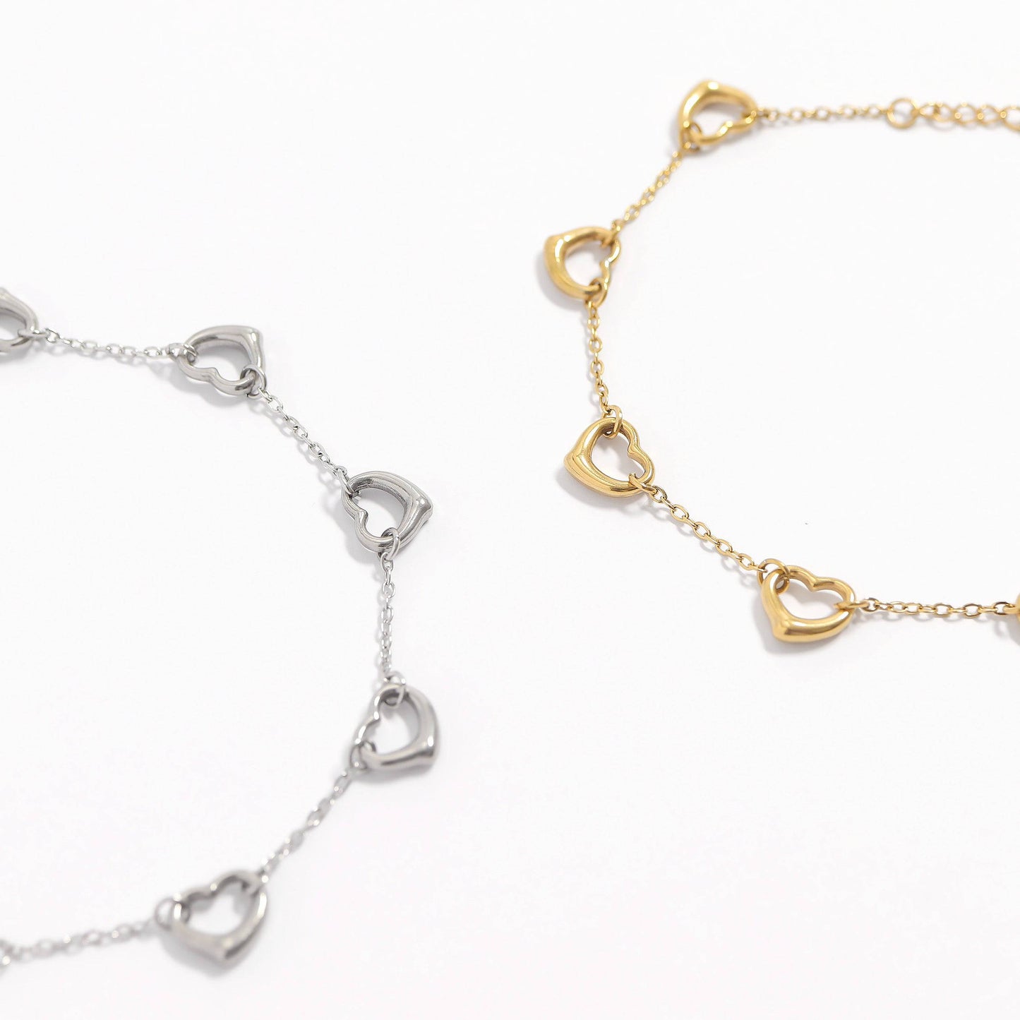 Gold and silver open heart bracelets side by side, made from waterproof, hypoallergenic stainless steel—perfect for everyday wear or gifting.