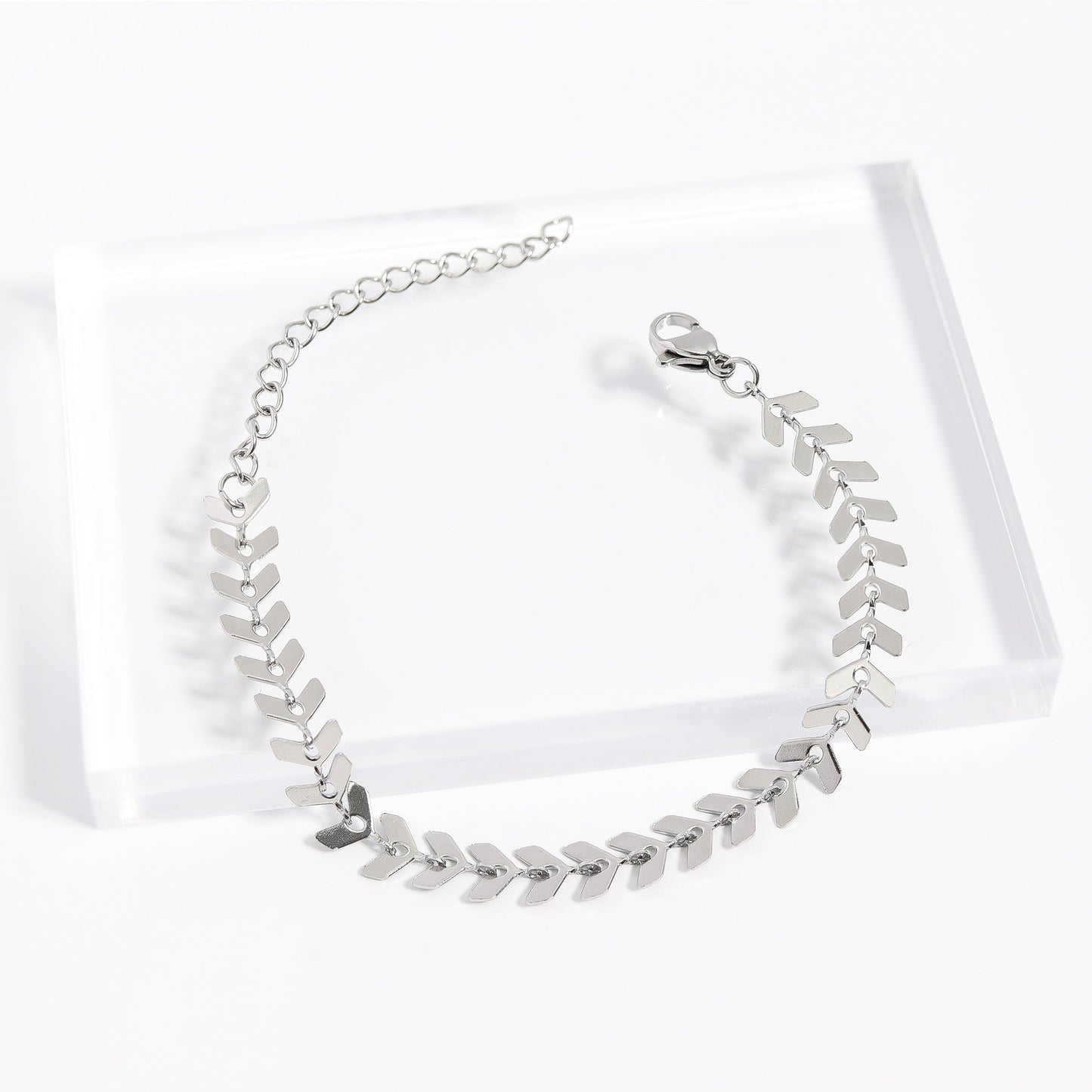Silver stainless steel herringbone bracelet on acrylic stand - elegant and waterproof design
