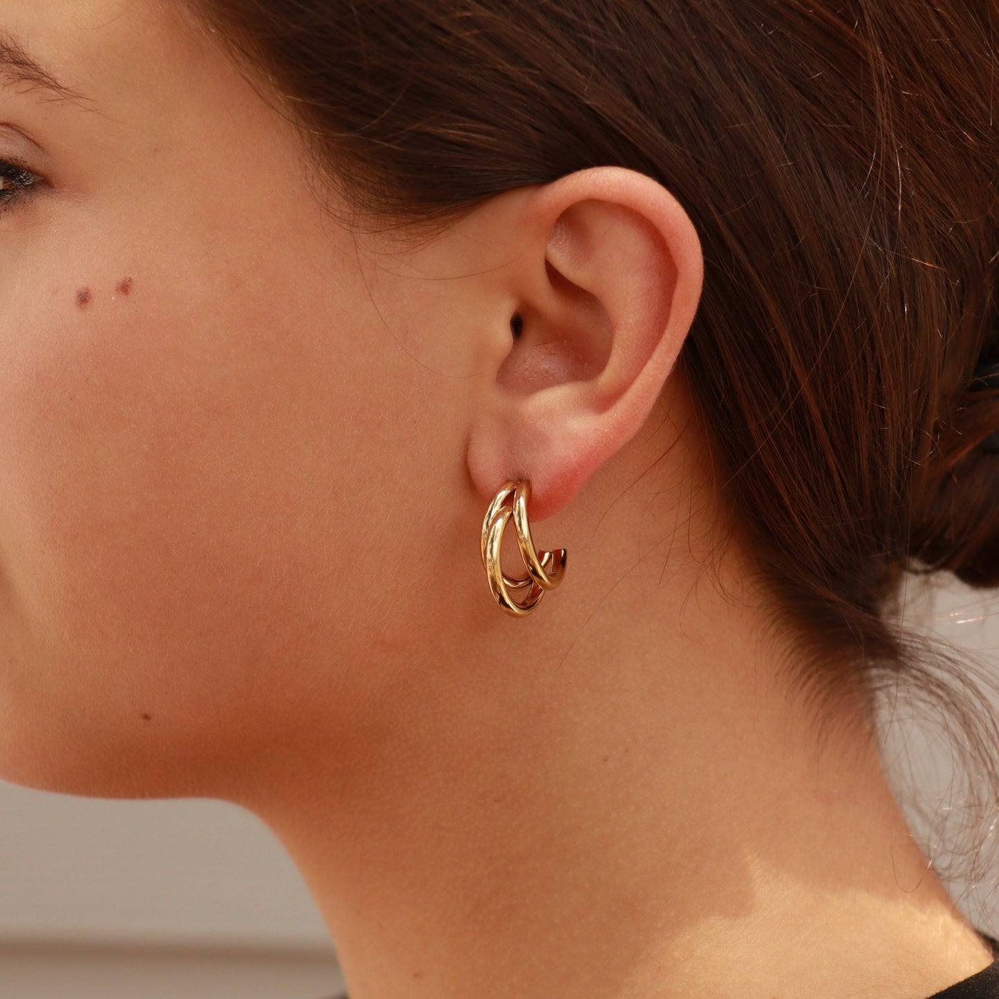 Gold triple layer hoop earrings on ear – waterproof, hypoallergenic, and tarnish-resistant PVD-coated stainless steel jewelry