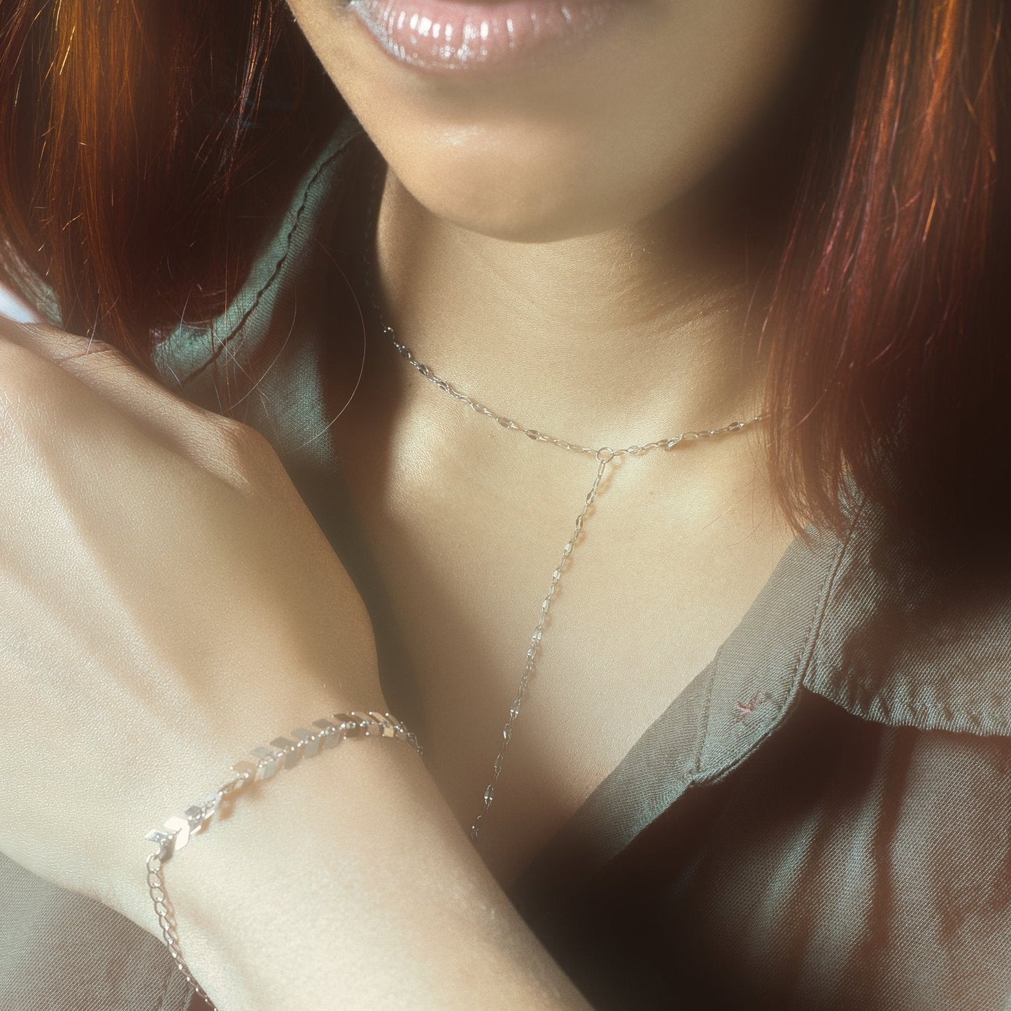 Silver Y-lariat necklace and reflective disc chain bracelet styled on model – hypoallergenic stainless steel jewelry that’s waterproof, tarnish-resistant, and perfect for minimal everyday elegance.