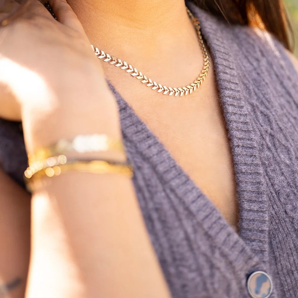 layered-gold-and-silver-herringbone-chain-bracelets-and-necklace-outdoor