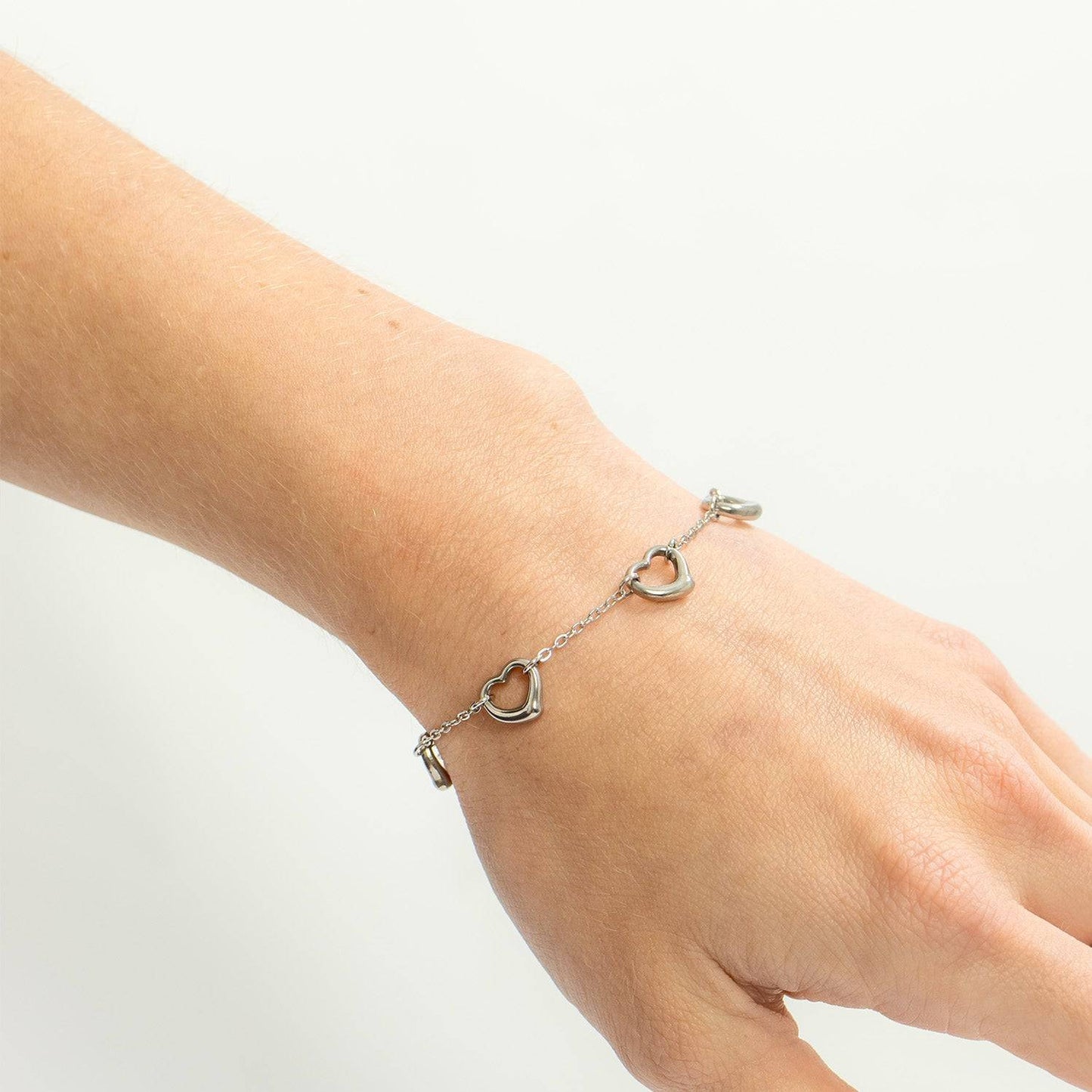 Silver heart link bracelet worn on wrist, minimalist and waterproof design, nickel-free and perfect for daily stacking style.