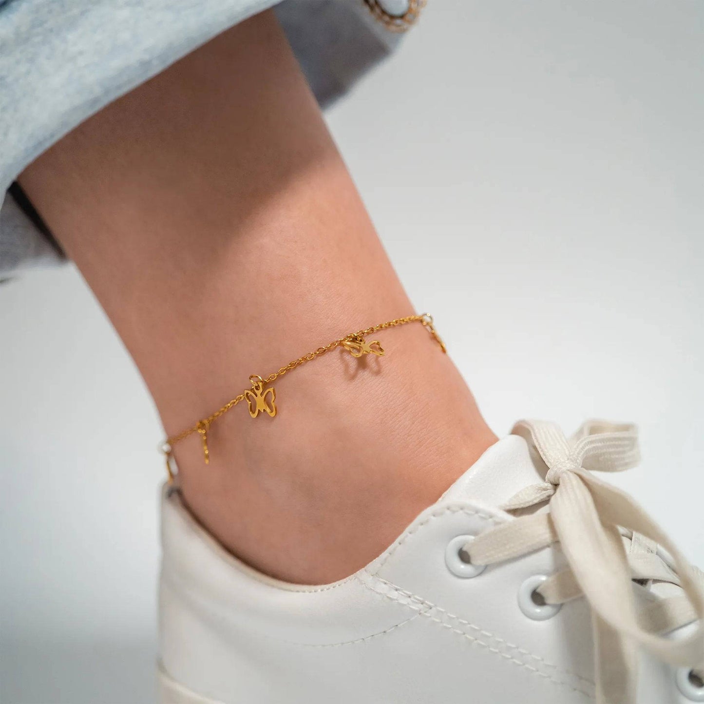 Gold butterfly charm anklet for women – layered ankle bracelet styled with sneakers, waterproof PVD finish for everyday fashion and summer wear
