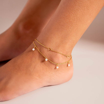 Gold anklet with dainty pearl charms styled on ankle – layered, waterproof beach jewelry by Lauren Riley Jewelry