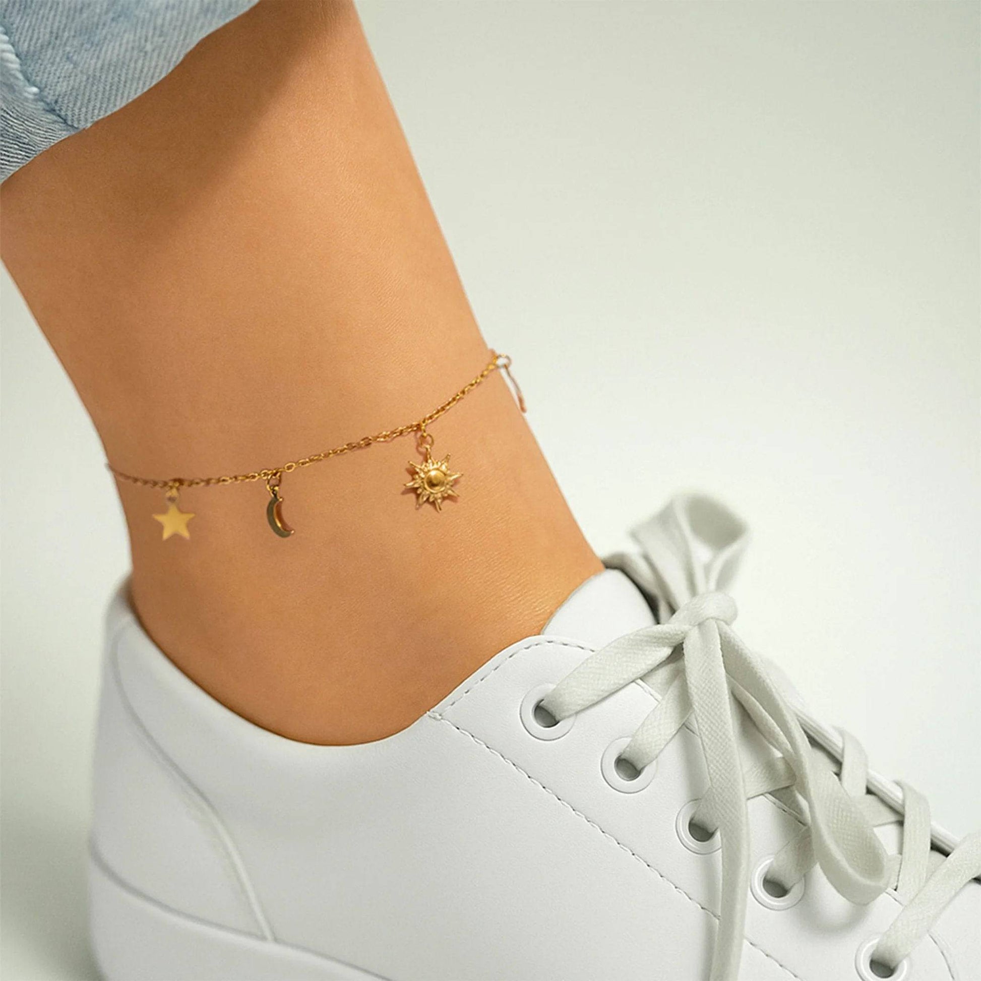 Gold celestial anklet featuring sun, moon, and star charms – dainty and trendy ankle bracelet for women, perfect for summer outfits, beach days, and layered jewelry looks