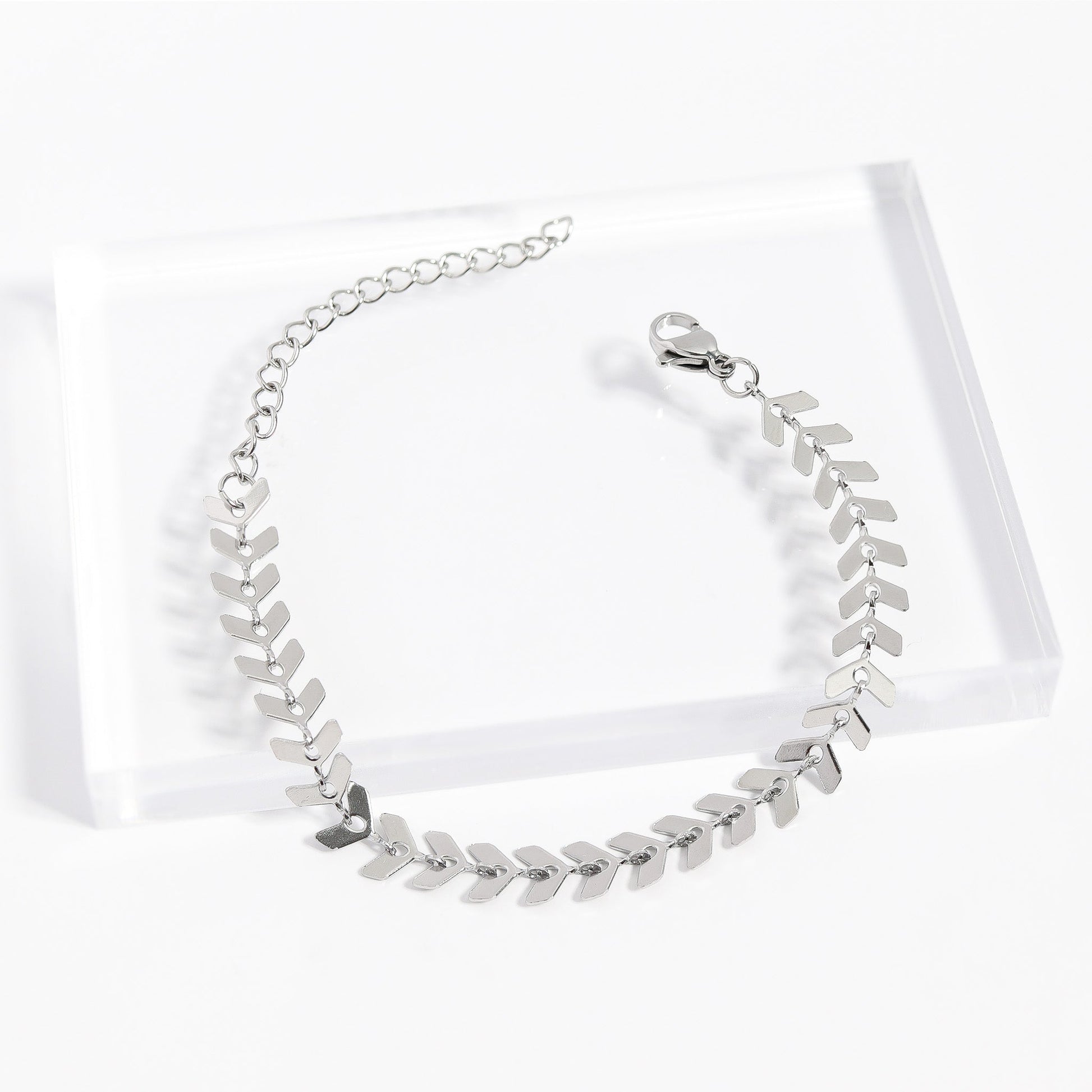 Silver stainless steel herringbone bracelet on acrylic stand - elegant and waterproof design
