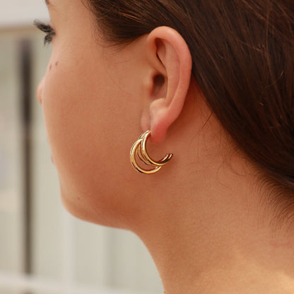 Model wearing gold triple layer hoop earrings – hypoallergenic, waterproof stainless steel jewelry with high-shine PVD finish