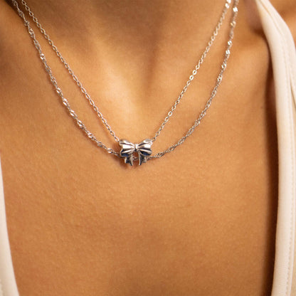 Layered silver bow necklace on model’s neck, waterproof and hypoallergenic from Lauren Riley Jewelry
