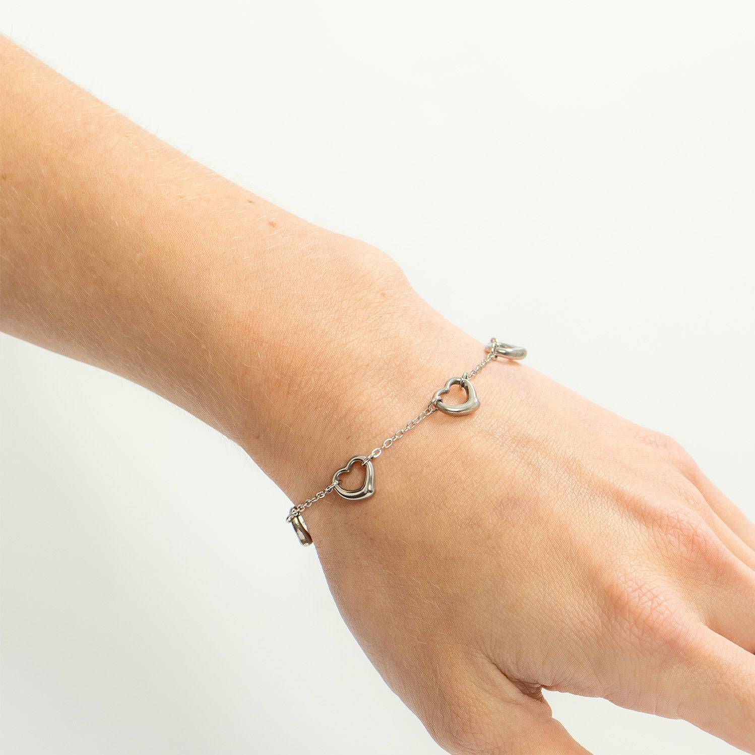 Silver heart link bracelet worn on wrist, minimalist and waterproof design, nickel-free and perfect for daily stacking style.